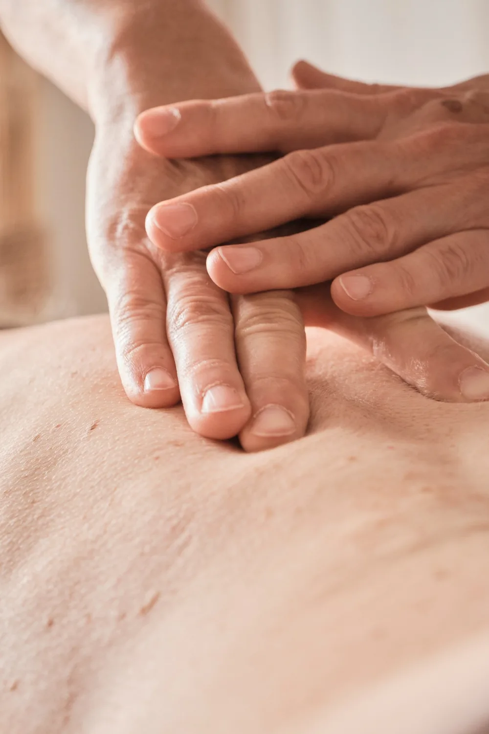 Primo piano delle dita che esercitano una pressione leggera accanto alle vertebre